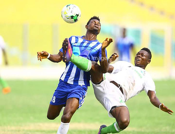 A Gt. Olympics player (white and blue) and an Elmina Sharks player fight for the ball in their Week 3 clash played at the Accra Sports Stadium on Wednesday, 22nd Feb 2017. File photo credit – S. A. Adadevoh.